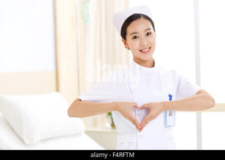 Young female nurses make a heart gesture Stock Photo