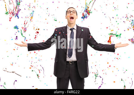 Studio shot of an overjoyed businessman standing in the middle of a lot of confetti streamers isolated on white background Stock Photo
