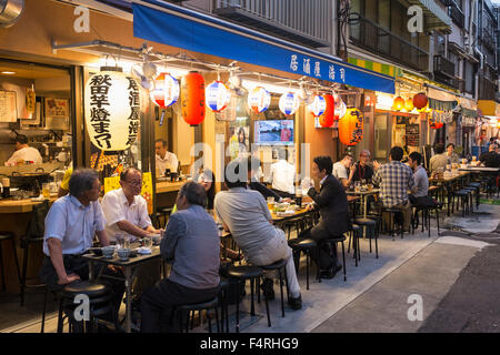 Small outdoor restaurants on street in the evening in Rokku entertainment district of Asakusa adjacent to SensoJi shrine Tokyo Stock Photo