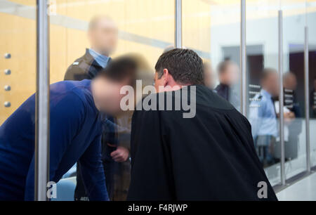 Duesseldorf, Germany. 22nd Oct, 2015. A defendants (L) speaks with his defense lawyer from behind a glass pane prior to the start of trial in the Higher Regional Court in Duesseldorf, Germany, 22 October 2015. The four accused men are to have organized the trip from Germany to Syria for multiple people wanting to take part in jihad in Syria for the IS. Photo: MONIKA SKOLIMOWSKA/dpa (ATTENTION EDITORS: the faces of the defendants and judicial officers have been pixilated for reasons of personal rights)/dpa/Alamy Live News Stock Photo