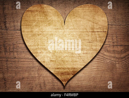 Wooden heart placed on a brown wood board Stock Photo