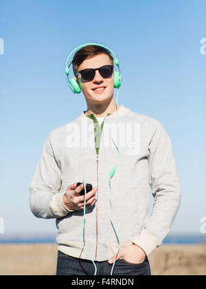 happy young man in headphones with smartphone Stock Photo