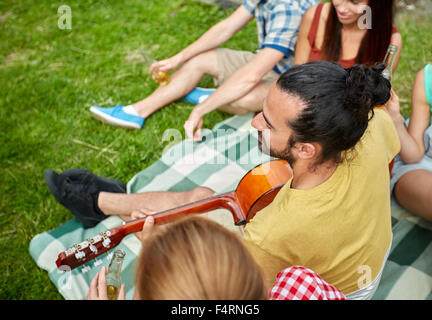 happy man with friends playing guitar at camping Stock Photo