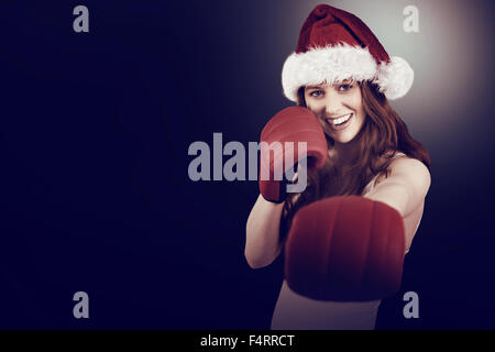 Festive redhead punching with boxing gloves Stock Photo