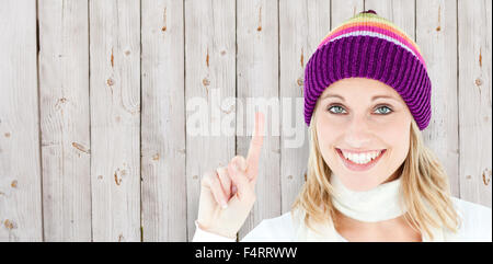 Composite image of positive woman showing up smiling at the camera against white background Stock Photo