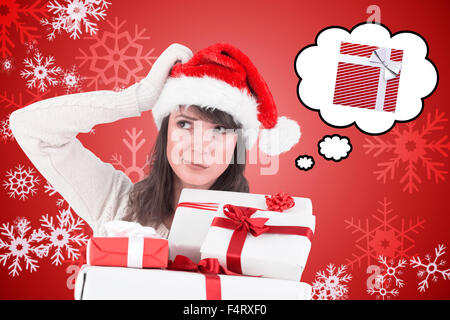 Composite image of santa woman scratching head and holding gifts Stock Photo