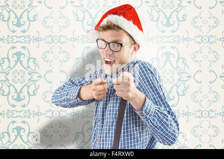 Composite image of geeky hipster wearing santa hat Stock Photo