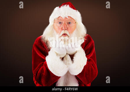 Composite image of santa claus blows something away Stock Photo