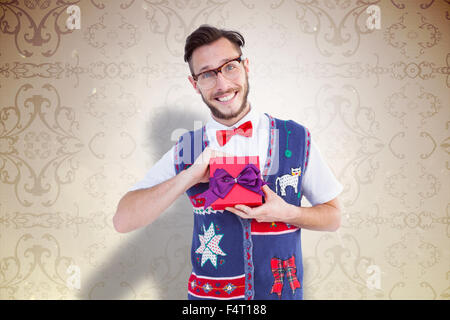 Composite image of geeky hipster offering christmas gift Stock Photo