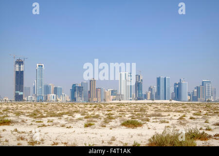 Daytime skyline view of  modern high-rise apartment buildings from desert  in Sharjah United Arab Emirates Stock Photo