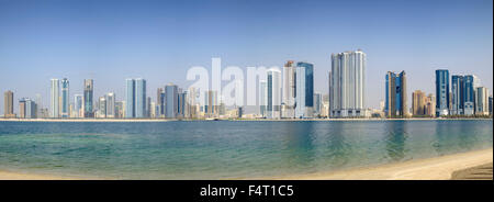 Daytime skyline view of beach and modern high-rise apartment buildings along Corniche in Sharjah United Arab Emirates Stock Photo