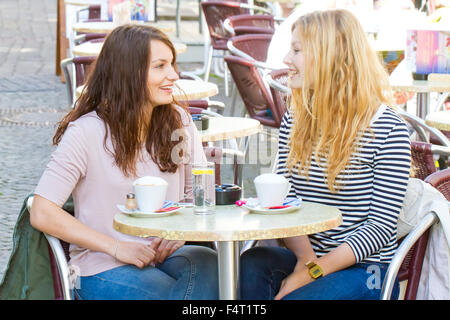 Two happy girls in a street cafe Stock Photo