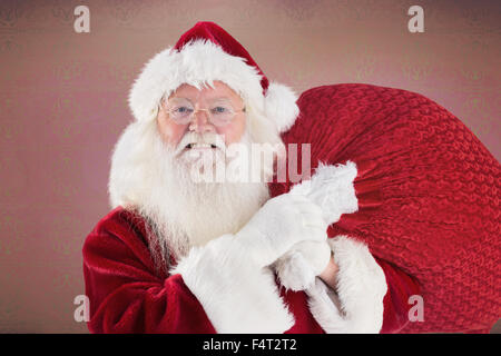 Composite image of jolly santa carries his sack Stock Photo