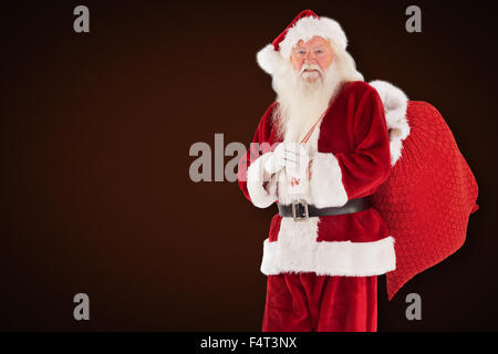 Composite image of santa carries his red bag Stock Photo - Alamy
