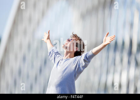 Excited Young Man Stretching out his Arm in Emotion Outdoors Stock Photo