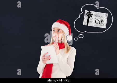 Composite image of festive blonde writing her christmas list Stock Photo