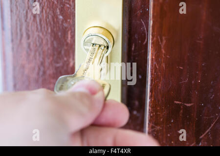 A man puts a high security key into a Yale high security TS007 one star 1* security lock. Stock Photo