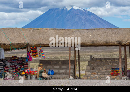 South America, Latin America, Peru, Altiplano, native woman knitting near volcano Stock Photo