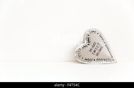 tin heart against white wall Stock Photo