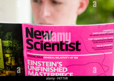 A young professional man reading the New Scientist Stock Photo