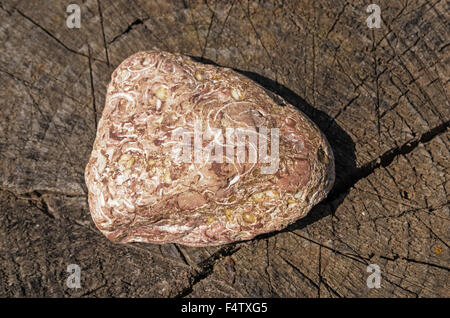 Pink dolomite stone on wooden gray stub. Stock Photo