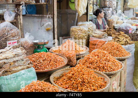 vietnamese lady selling dried fish shrimps prawns at her indoor stall in Hanoi old quarter market,Vietnam Stock Photo