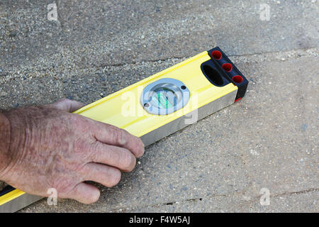 a male hand holding a level tool Stock Photo