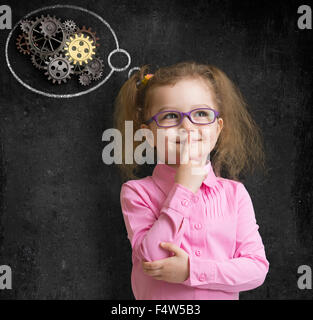 kid girl in glasses with bright idea standing near school blackboard Stock Photo