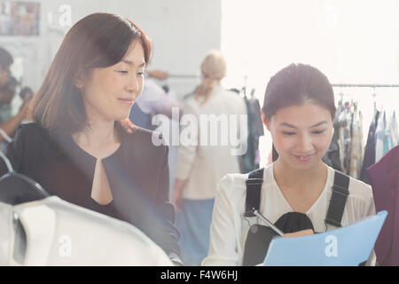 Fashion designer watching assistant taking notes Stock Photo