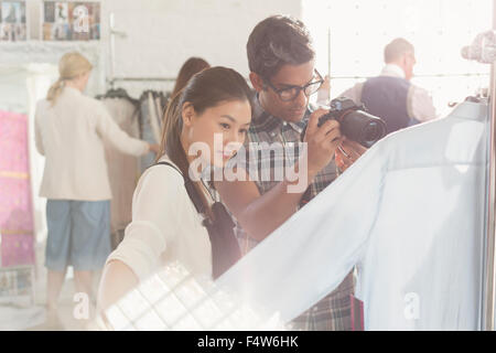 Photographer and fashion designer examining clothing Stock Photo