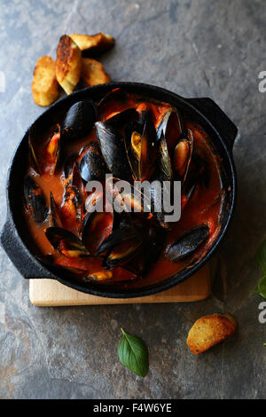 mussels in red sauce in pan Stock Photo