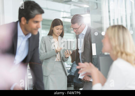 Business people sharing digital tablet in conference room Stock Photo