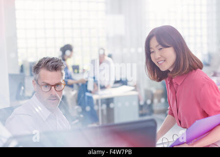 Business people using computer at desk in office Stock Photo