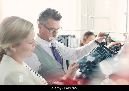 Fashion designers examining clothing Stock Photo