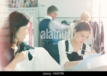 Fashion designers taking notes on clothing Stock Photo