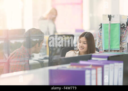 Fashion designers talking at desk in office Stock Photo