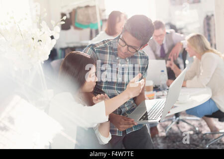 Fashion designers brainstorming with laptop in office Stock Photo