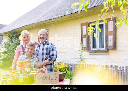 Portrait proud grandparents and grandson selling honey Stock Photo
