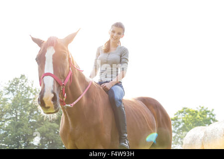 Smiling woman riding horse bareback Stock Photo