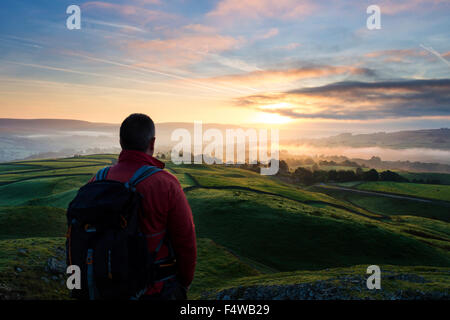 Hiker Enjoying the View Across a Misty Teesdale at Sunrise From Kirkcarrion, Lunedale, Teesdale County Durham UK