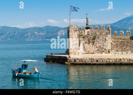 An unidentified fisherman in his traditional wooden boat leaves the harbor, going to work on June 17, 2013 in Nafpaktos, Greece. Stock Photo