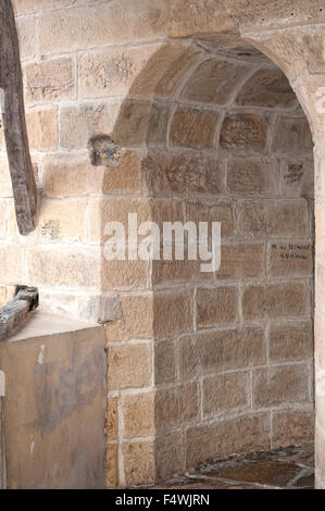 Narrow passage cobblestoned with archs outside the church of St. Nicholas in Orio. Basque Country. Stock Photo