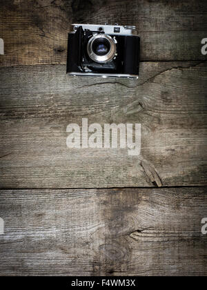 antique photo camera on wooden weathering background Stock Photo