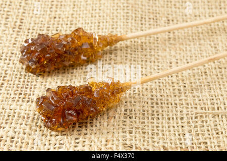 Two crystallized brown sugar sticks on rustic tablecloth Stock Photo