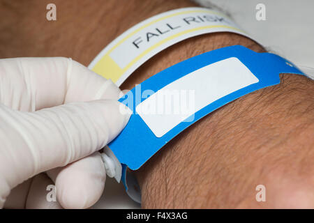 Nurse checks hospital patient identification bracelet. Stock Photo