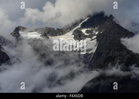 Hanging glaciers and clouds on the mountain tops near port of Skagway Alaska | Lynn Canal fjord cruise - inside passage Stock Photo
