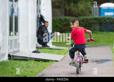 Duesseldorf, Germany. 22nd Oct, 2015. Seven-year-old refugee boy Sengin rides his bike in front of a refugee shelter in Duesseldorf, Germany, 22 October 2015. Photo: Monika Skolimowska/dpa/Alamy Live News Stock Photo