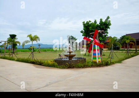 Decoration of gardening Pin wheel or windmill and fountain in garden at Phrae, Thailand Stock Photo