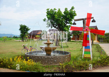 Decoration of gardening Pin wheel or windmill and fountain in garden at Phrae, Thailand Stock Photo