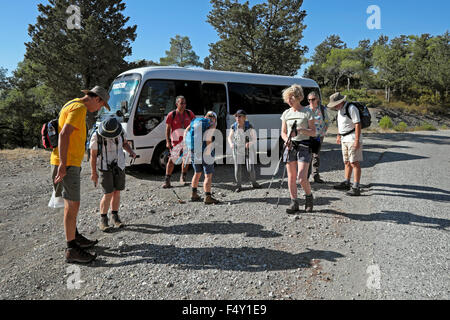 A walking group of older people next to tour bus checking out their boots prepare to set out for a walk on a trail in North Cyprus  KATHY DEWITT Stock Photo